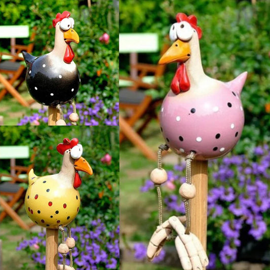 Kolorowe ceramiczne kury z wiszącymi nogami w ogrodzie